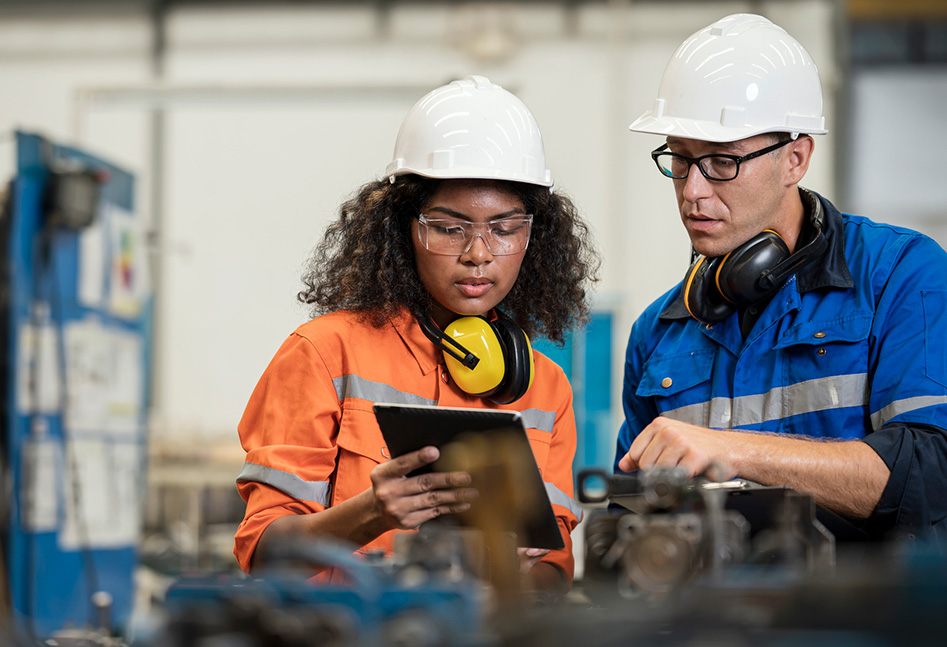 Man and woman in hardhats talking at work