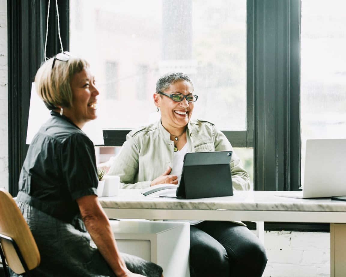 Two women laughing at a presentation